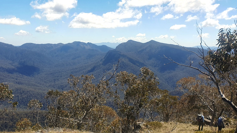 Majestic scenery of the Australian Alps, with two trekkers showing tiny in the foreground